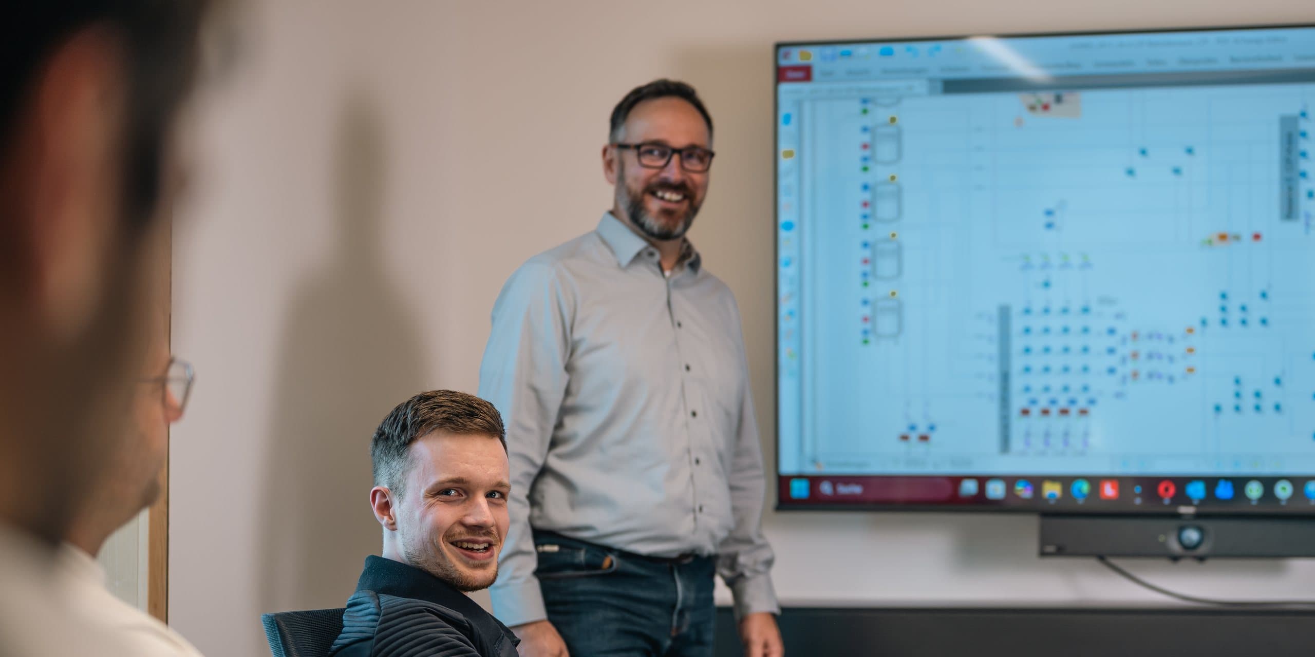 Two ecc engineers in front of a plant schematic in the meeting room